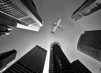 Skyscrapers with aircraft in sky
