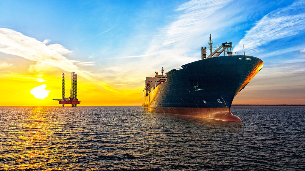 Oil tanker at sea, platform in background