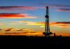 Oil rig on land at sunset