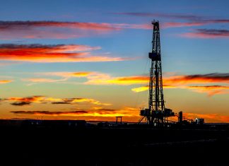 Oil rig on land at sunset