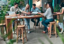 People meeting around table in office with biophilic design