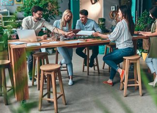 People meeting around table in office with biophilic design