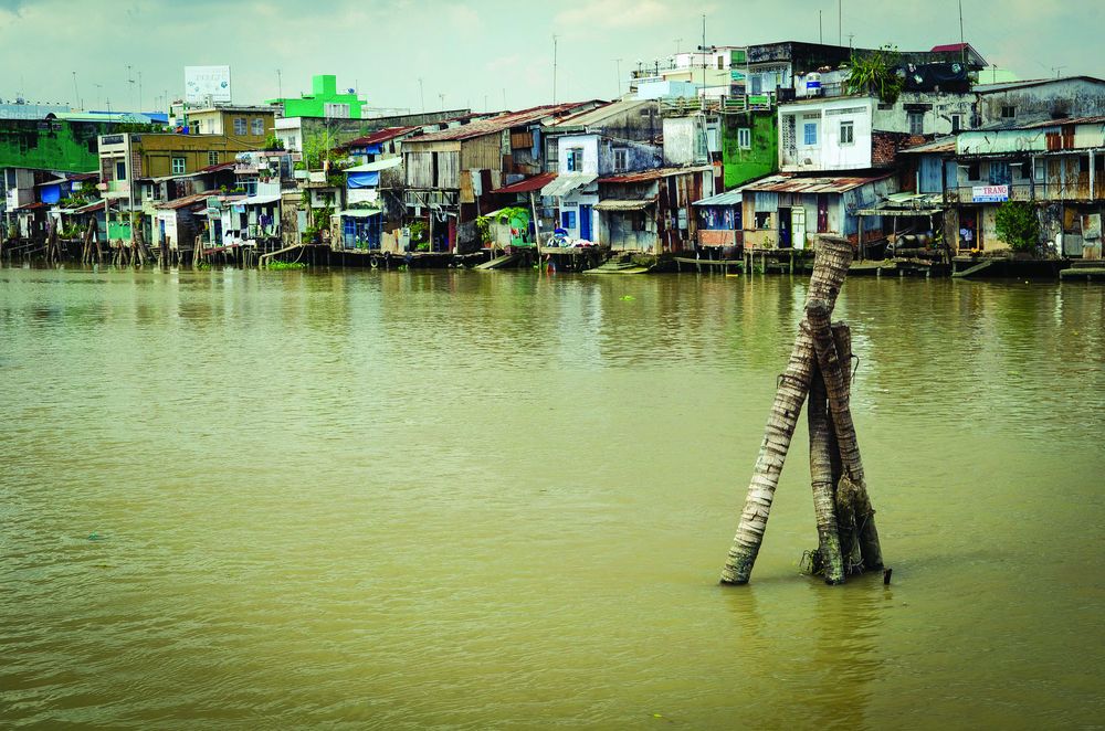 Slum houses by a river in Vietnam. Poverty, a target of SDG1