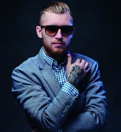 Man in suit, with tattoo on hand
