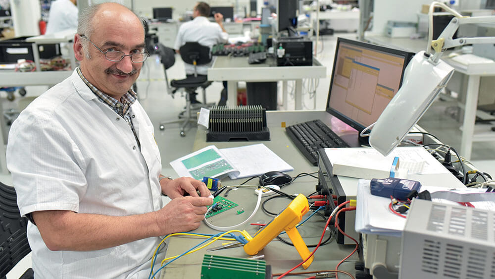 Older man at electronics workbench. Unconscious bias illustration